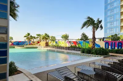 a pool at a resort with chairs and palm trees at High-Floor Skyline View Near Safa Park and Godolphin Stables with Easy Access to Dubai Mall and Canal, Aykon City 2 Tower C, Business Bay by Deluxe Holiday Homes in Dubai
