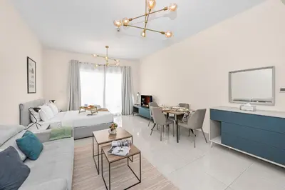 a living room with a bed and a tv in it at Enjoy Modern Comforts with Views of Burj Al Aráb and Nearby Attractions in Dubai