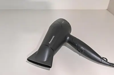 a black hair dryer sitting on a table at Enjoy Modern Comforts with Views of Burj Al Aráb and Nearby Attractions in Dubai