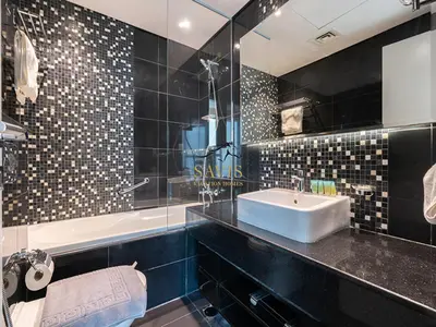 a bathroom with a sink and a mirror and a tub at Savis Homes - The Voleo - Bright and elegant studio - Business Bay in Dubai in Dubai