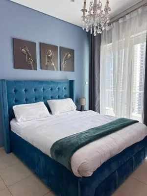 a blue bedroom with a large bed and a chandelier at Luxury 2 BR Apartment Marina View in Dubai