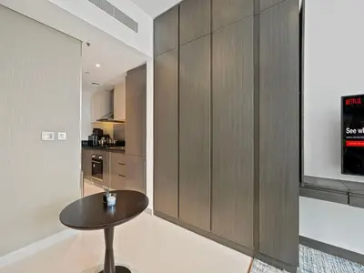 a room with a table and a kitchen at Livin' Holidays - Studio - Close to downtown in Dubai