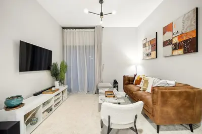 a living room with a couch and a tv at FIRST CLASS 1BR Elegant Comfort Awaits in Dubai