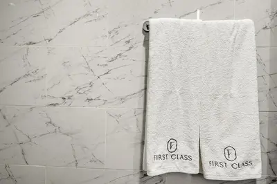 a white first class towel hanging in a bathroom at FIRST CLASS 1BR Elegant Comfort Awaits in Dubai