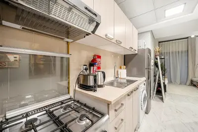 a kitchen with a stove and a sink at FIRST CLASS 1BR Elegant Comfort Awaits in Dubai