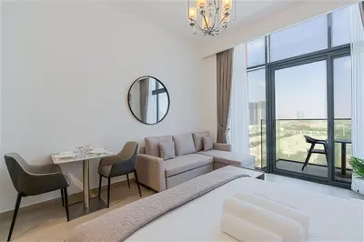 a bedroom with a bed and a couch and a table at Studio Apartment near Al Quoz Pond Park in Dubai