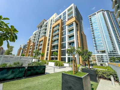a large apartment building with trees in a park at Studio Apartment near Al Quoz Pond Park in Dubai