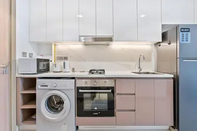 a kitchen with a washing machine and a sink at Studio Apartment near Al Quoz Pond Park in Dubai