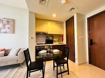 a kitchen and a dining room with a table and chairs at Elite & Classy Furnished and Exquisite Living Room in Dubai
