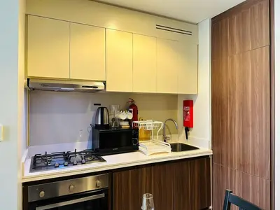 a kitchen with a stove and a microwave at Elite & Classy Furnished and Exquisite Living Room in Dubai