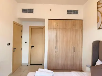 a bedroom with wooden cabinets in a room at Exclusive Retreat and Spacious Unit in JVC in Dubai