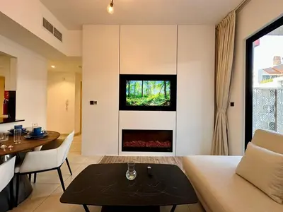 a living room with a couch and a fireplace at Exclusive Retreat and Spacious Unit in JVC in Dubai