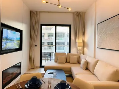 a living room with a couch and a table at Exclusive Retreat and Spacious Unit in JVC in Dubai