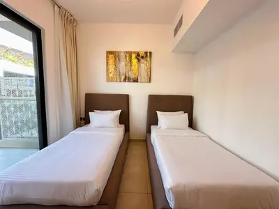 two beds in a room with a window at Exclusive Retreat and Spacious Unit in JVC in Dubai
