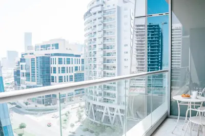 a balcony with a view of a city with tall buildings at Luxury Studio l Rooftop Pool & Gym Access in Dubai
