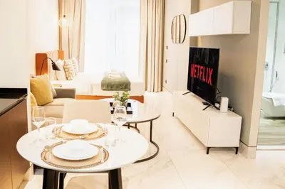 a living room with a table and a tv at Luxury Studio l Rooftop Pool & Gym Access in Dubai