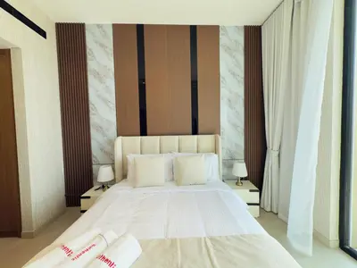 a bedroom with a large white bed with two lamps at Brand New with Installed Private Pool in Balcony in Dubai