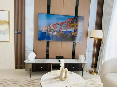 a living room with a tv hanging on a wall at Brand New with Installed Private Pool in Balcony in Dubai