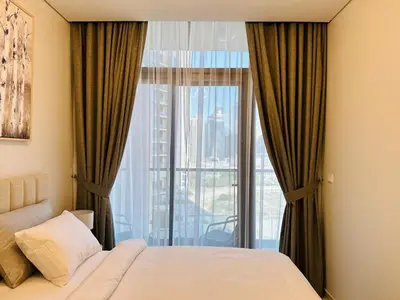 a bedroom with a bed and a large window at Cozy Haven High Rise Balcony and Upscale Furnished in Dubai