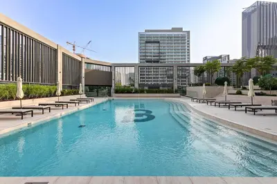 a large swimming pool with chairs and a building at Modern Studio at Paragon with City View in Dubai