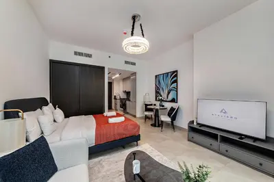 a bedroom with a bed and a flat screen tv at Modern Studio at Paragon with City View in Dubai