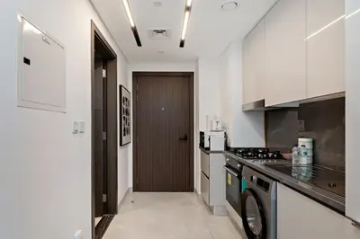a kitchen with a stove and a washer and dryer at Modern Studio at Paragon with City View in Dubai