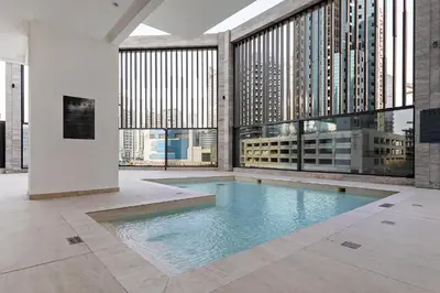 an indoor swimming pool in a building with large windows at Modern Studio at Paragon with City View in Dubai