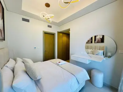 a bedroom with a large bed and a mirror at Sleek Charm Inviting Atmosphere and Cozy Balcony in Dubai