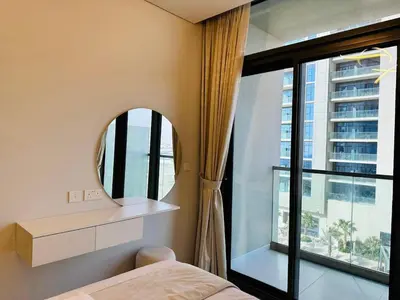 a bedroom with a mirror and a bed and a window at Sleek Charm Inviting Atmosphere and Cozy Balcony in Dubai