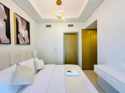 a bedroom with a white bed and a ceiling fan at Sleek Charm Inviting Atmosphere and Cozy Balcony in Dubai