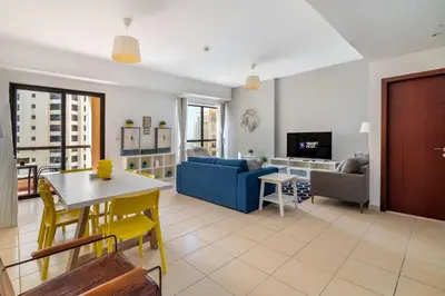 a living room with a couch and a table at Spacious 2BR Flat with Gym & Pool in JBR in Dubai