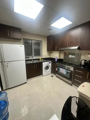 a kitchen with a white refrigerator and a dishwasher at Stay Inn AlBarsha by PHM in Sabkhah