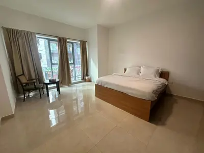 a bedroom with a bed and a chair and a window at Stay Inn AlBarsha by PHM in Sabkhah
