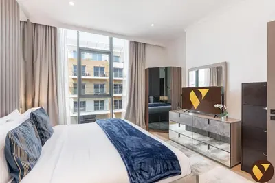 a bedroom with a bed and a large window at Vogue JVC Chaimaa Avenue near Circle Mall, One Bedroom Apartment with Balcony and City View, Access to all Amenities in Dubai