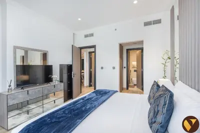 a bedroom with a large bed and a television at Vogue JVC Chaimaa Avenue near Circle Mall, One Bedroom Apartment with Balcony and City View, Access to all Amenities in Dubai