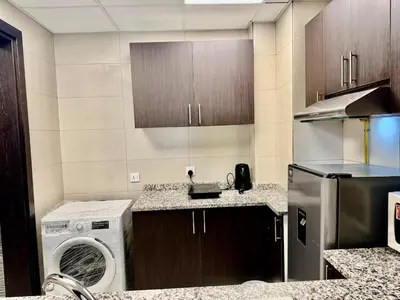 a kitchen with a washing machine and a washer at Jaddaf NS Building in Dubai