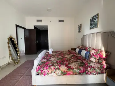 a bedroom with a large bed covered in flowers at Jaddaf NS Building in Dubai