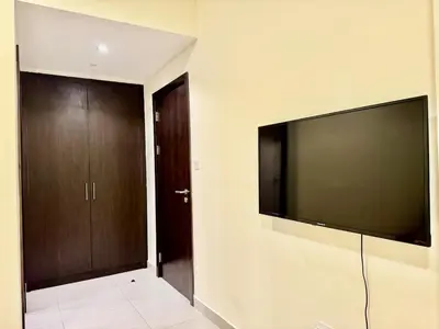 a living room with a large flat screen tv on the wall at Jaddaf NS Building in Dubai