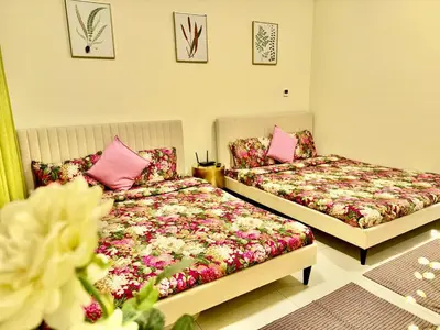 two beds in a room with pink pillows at Jaddaf NS Building in Dubai