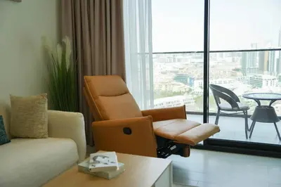 a living room with a couch and a chair at Modern & Stylish 1BR, Pool & Gym in Dubai