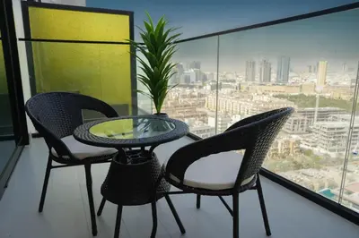a table and chairs on a balcony with a view at Modern & Stylish 1BR, Pool & Gym in Dubai