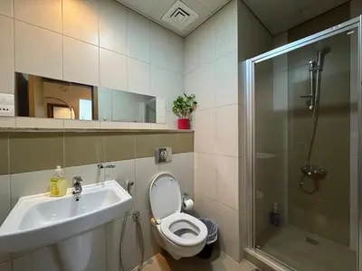 a bathroom with a toilet and a sink and a shower at Sandoval Gardens JVC in Dubai