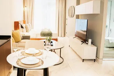 a kitchen and living room with a table and a couch at Chic Business Bay Retreat l Pool, Luxury Amenities in Dubai