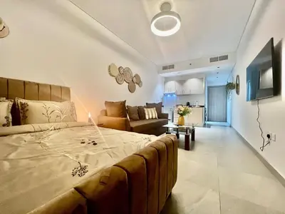 a bedroom with a large bed and a living room at Karama stunning unit for 4 in Dubai