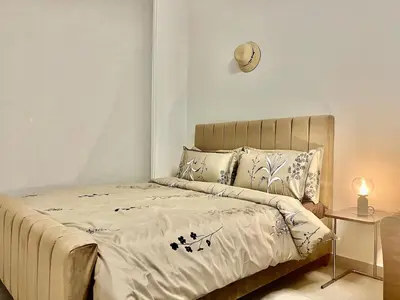 a bed in a bedroom with a clock on the wall at Karama stunning unit for 4 in Dubai