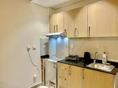 a small kitchen with a sink and a refrigerator at Karama stunning unit for 4 in Dubai
