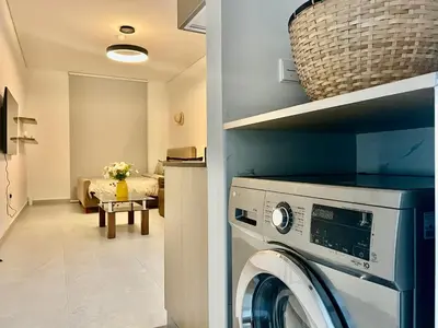a washer and dryer in a room with a bedroom at Karama stunning unit for 4 in Dubai