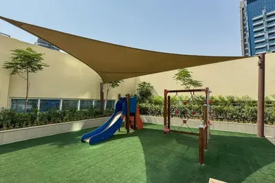 a play area with a slide and a playground at Chic Business Bay 1Bed Retreat with Canal Views in Dubai