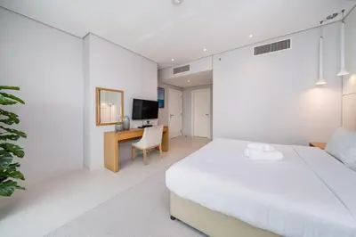 a white bedroom with a bed and a desk at Chic Business Bay 1Bed Retreat with Canal Views in Dubai