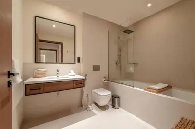 a bathroom with a toilet and a sink and a mirror at Seraya Residences at Marina Yacht Club - Vida Marina in Dubai